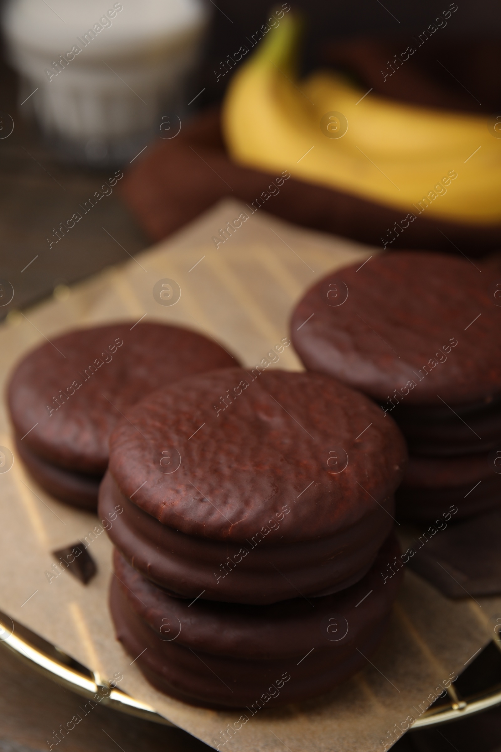 Photo of Delicious banana choco pies on wooden table, closeup