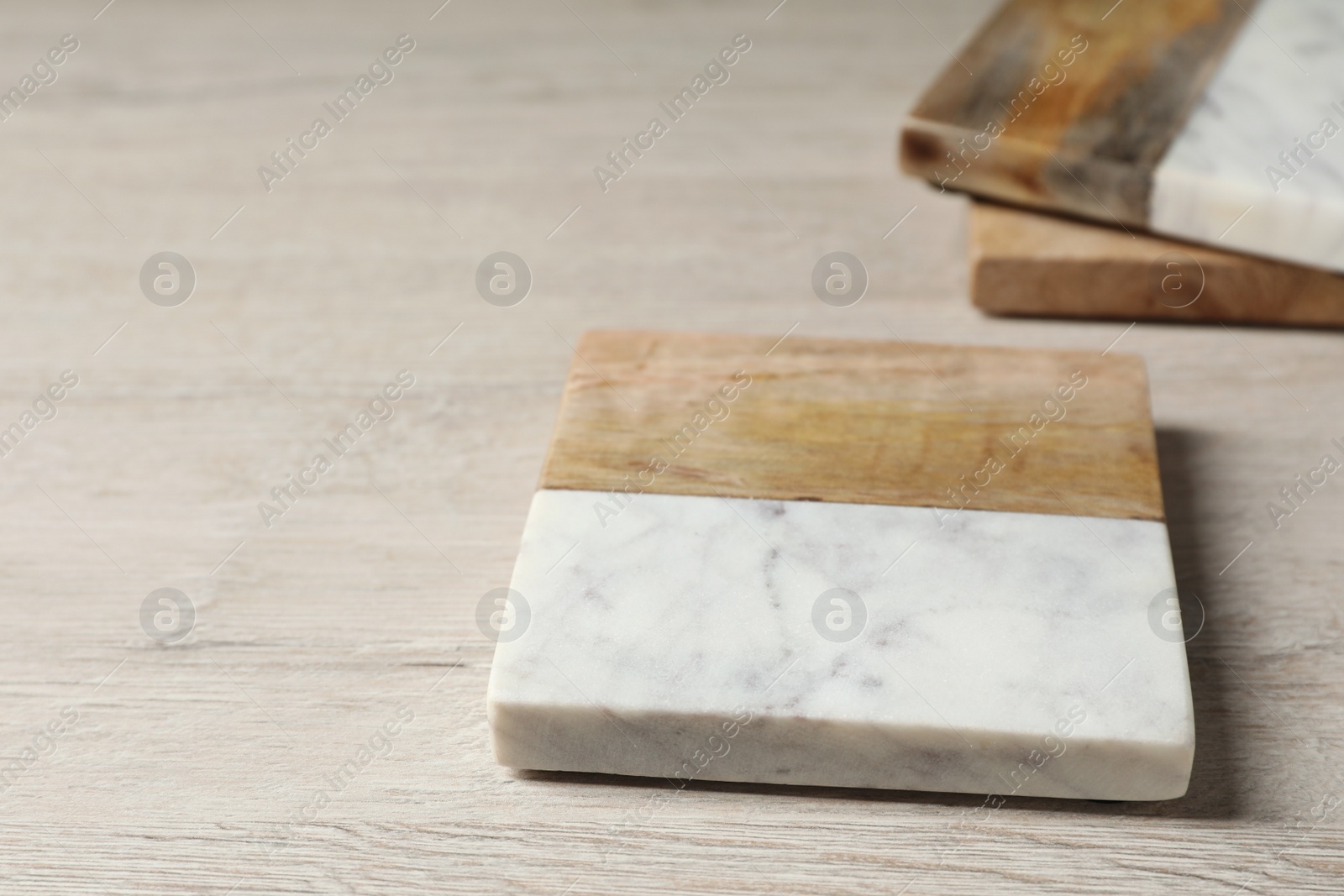 Photo of Stylish cup coaster on white wooden table, closeup. Space for text