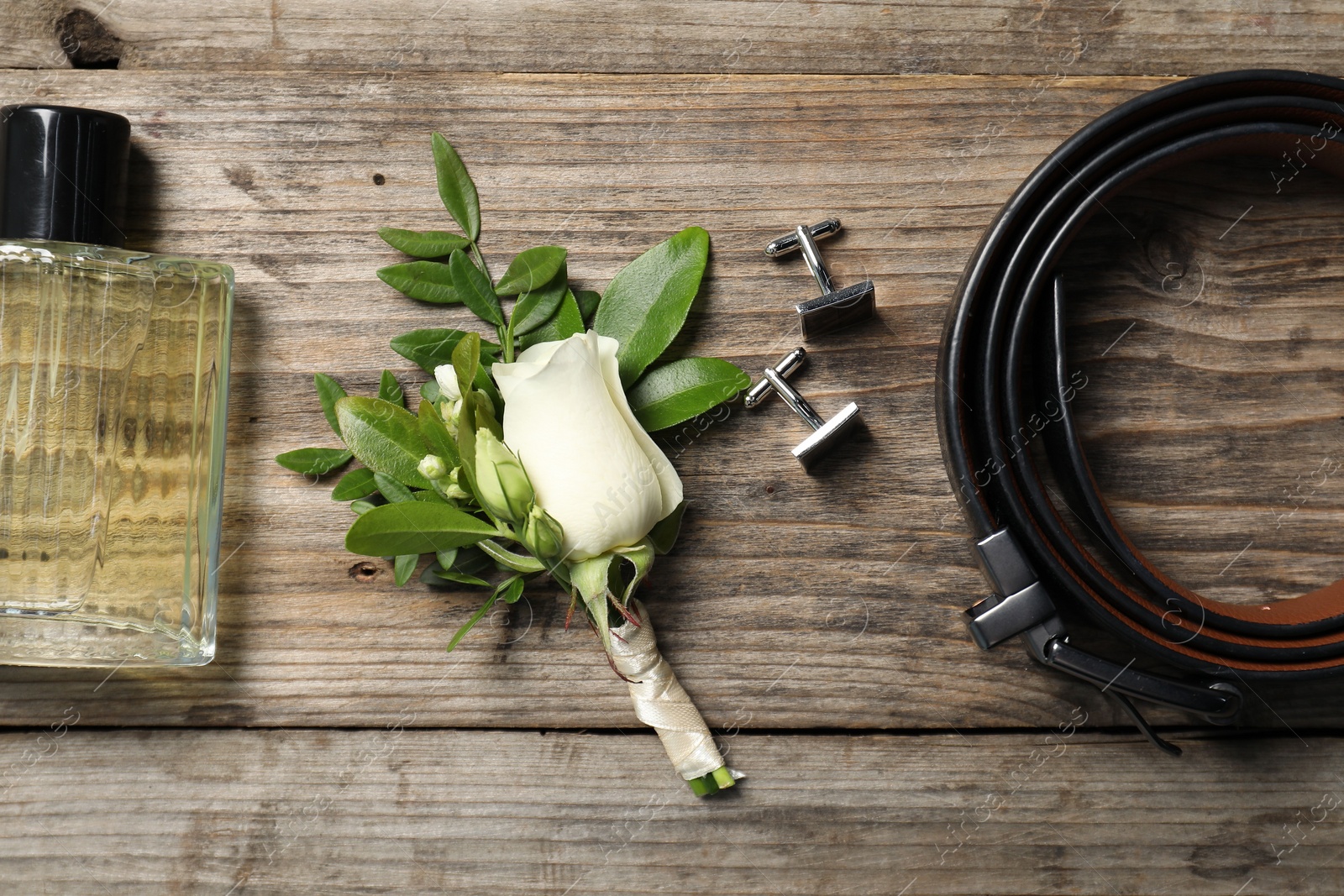 Photo of Wedding stuff. Flat lay composition with stylish boutonniere on wooden table