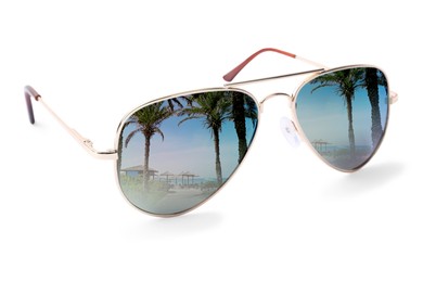 Image of New stylish aviator sunglasses on white background. Tropical beach and palm trees reflecting in lenses
