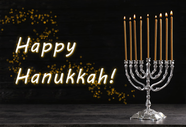 Image of Silver menorah on black wooden table. Happy Hanukkah!