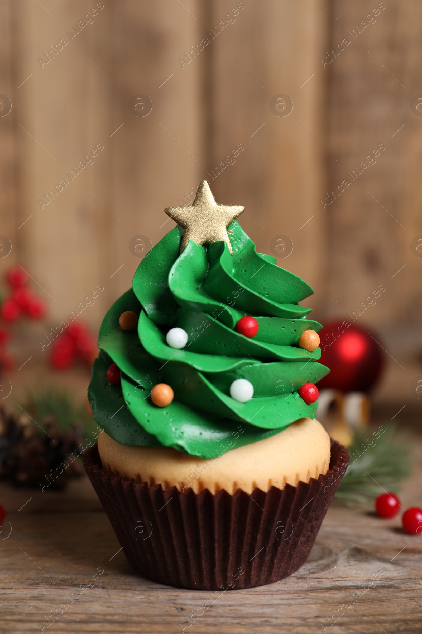 Photo of Christmas tree shaped cupcake on wooden table, closeup