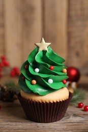 Christmas tree shaped cupcake on wooden table, closeup