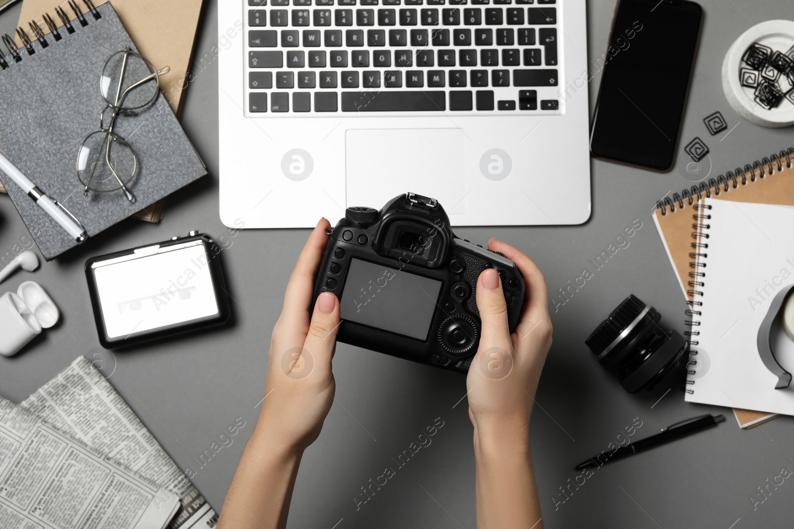 Photo of Journalist with camera at grey table, top view