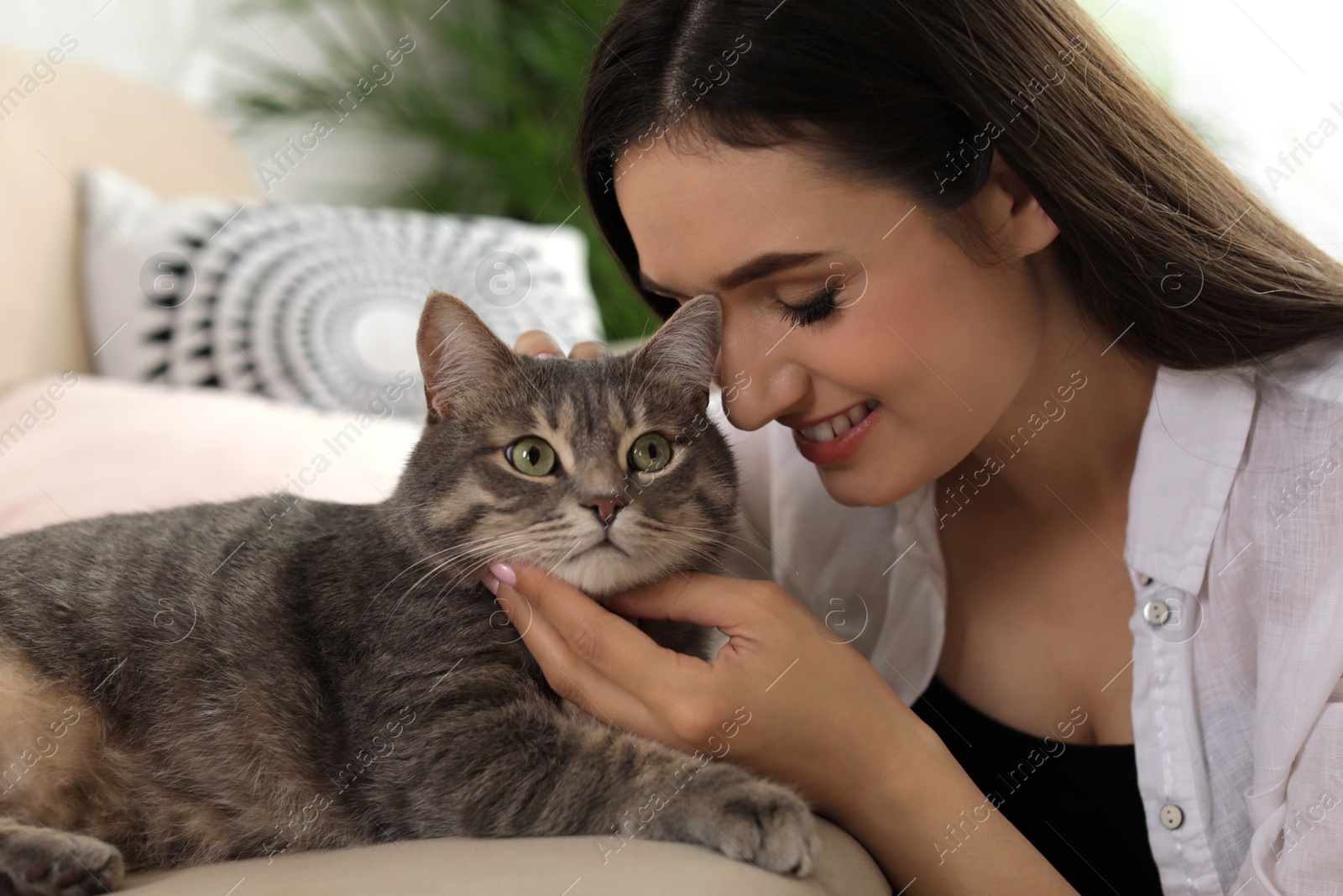 Photo of Young woman with cute cat at home. Pet and owner