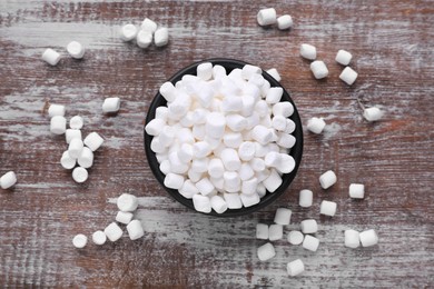 Bowl with delicious marshmallows on wooden table, flat lay