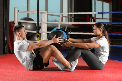 Photo of Young couple working out in modern gym