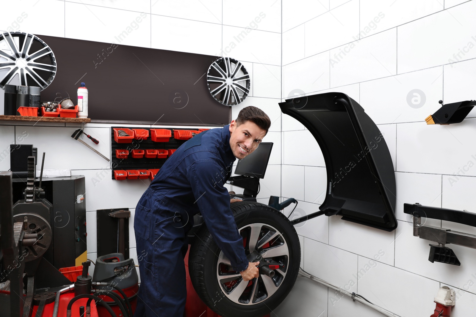Photo of Man working with wheel balancing machine at tire service