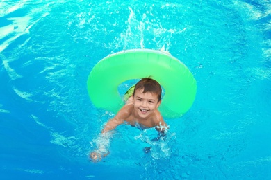 Little child with inflatable ring in outdoor swimming pool. Dangerous situation