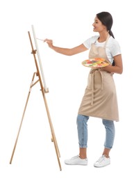 Young woman drawing on easel against white background