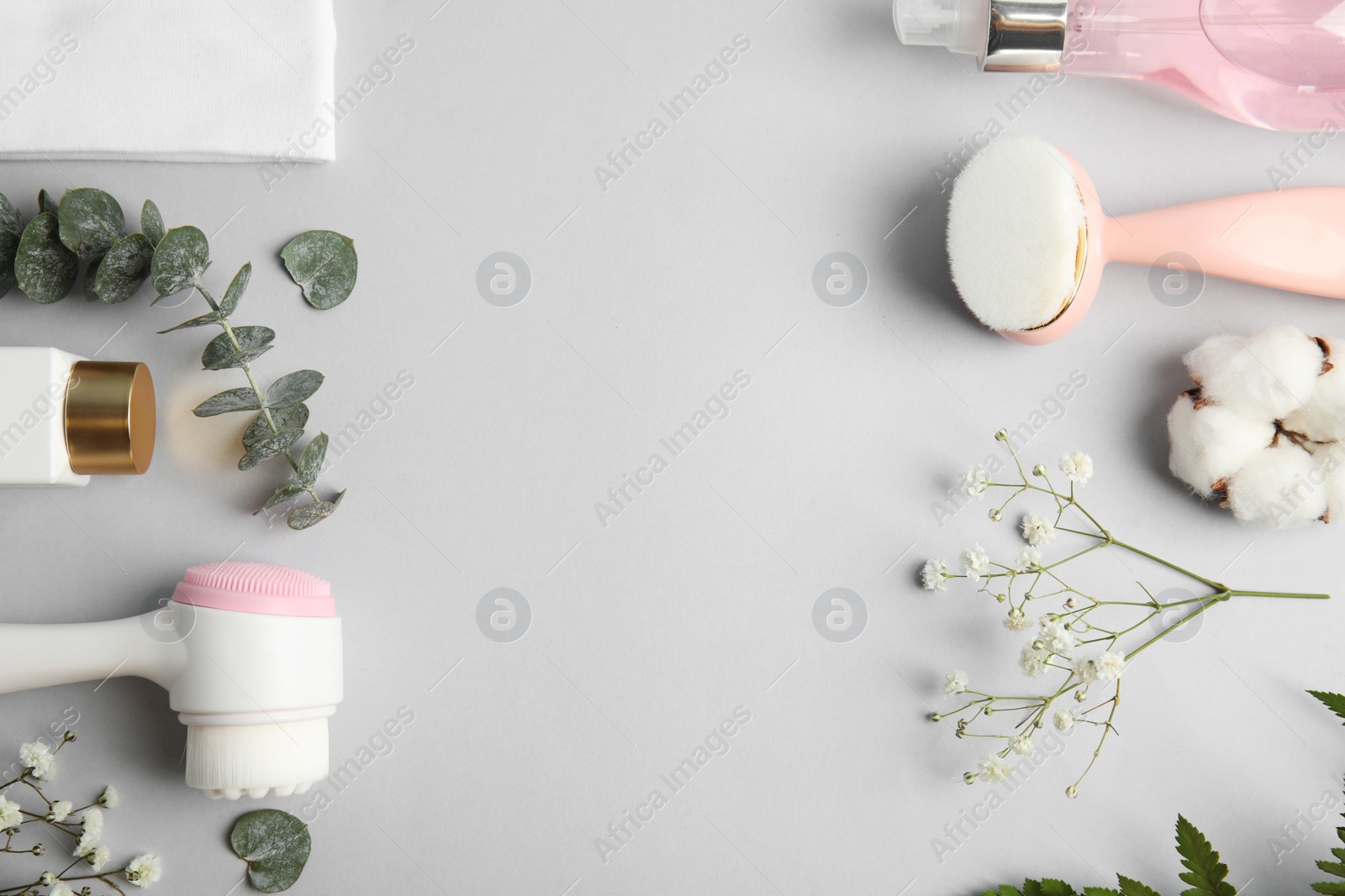 Photo of Flat lay composition with face cleansing brushes on light grey background. Cosmetic accessories