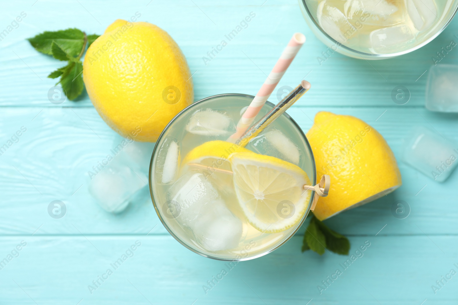 Photo of Natural lemonade and fresh fruits on light blue wooden table, flat lay. Summer refreshing drink