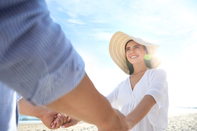 Happy couple holding hands on beach, closeup