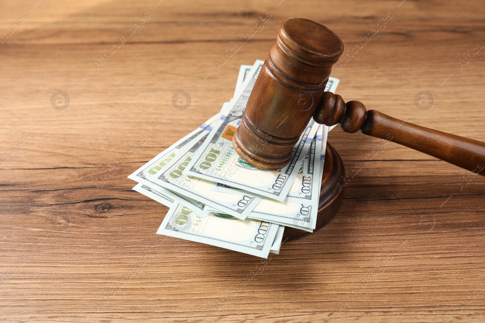 Photo of Judge's gavel and money on wooden table