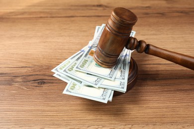 Judge's gavel and money on wooden table