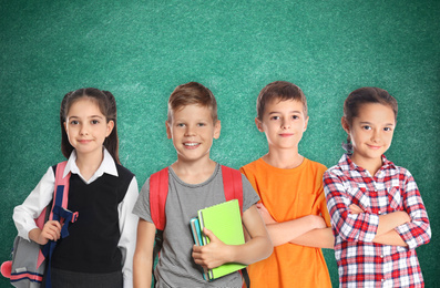 Group of cute school children and chalkboard on background