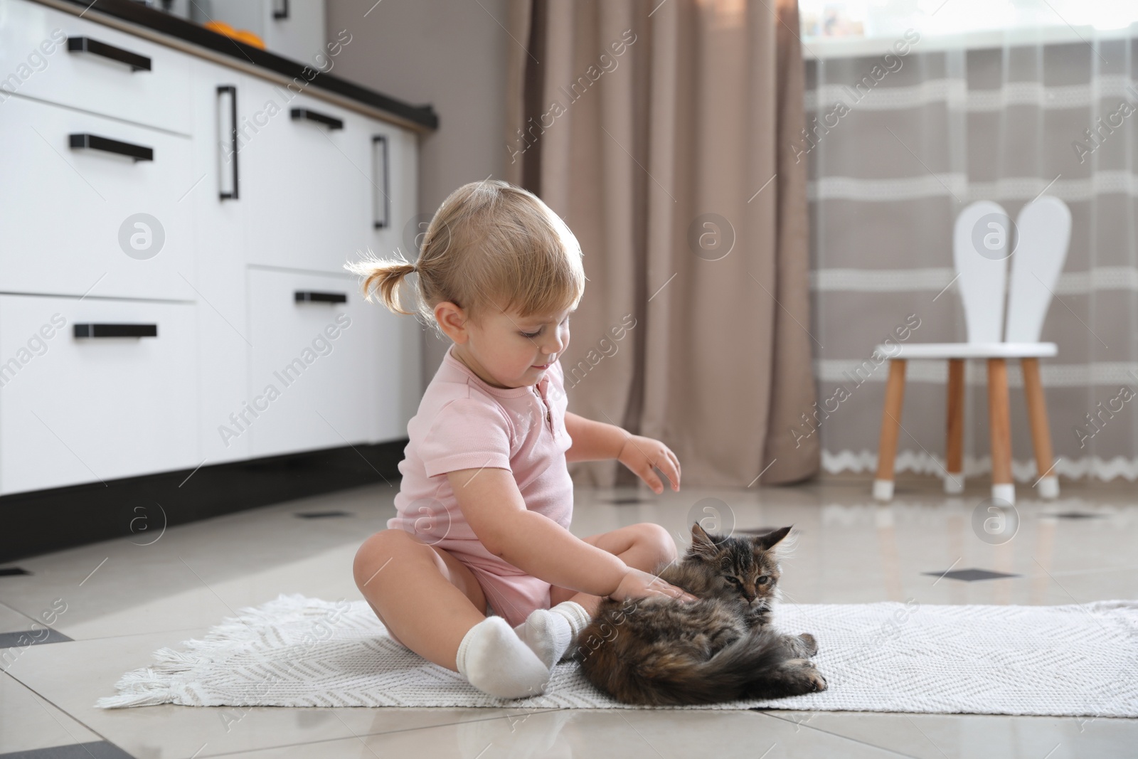 Photo of Cute little child with adorable pet on floor at home