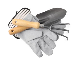 Photo of Gardening gloves, trowel and rake isolated on white