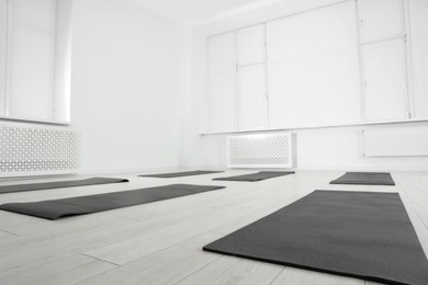 Photo of Spacious yoga studio with exercise mats and big windows, low angle view