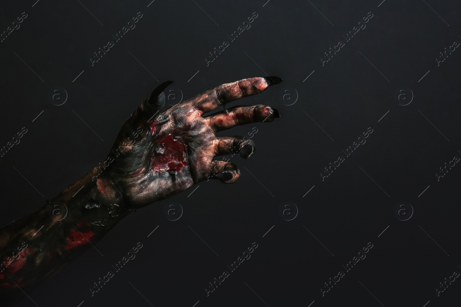 Photo of Scary monster on black background, closeup of hand. Halloween character