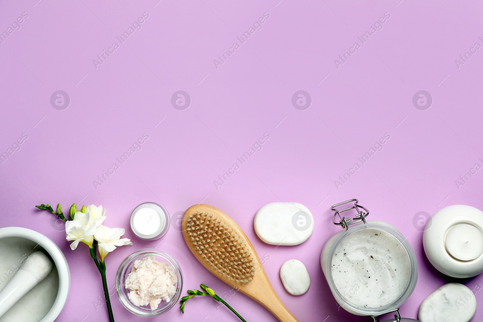 Photo of Flat lay composition with body scrub and spa stones on pale violet background, space for text