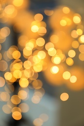 Blurred view of gold lights on dark background. Bokeh effect