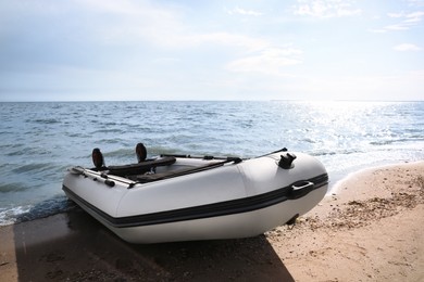 Photo of Inflatable rubber fishing boat on sandy beach near sea