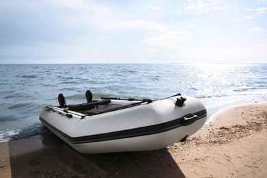 Inflatable rubber fishing boat on sandy beach near sea