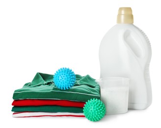 Color dryer balls, detergents and stacked clean clothes on white background