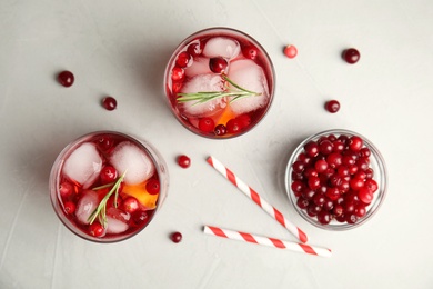 Photo of Tasty refreshing cranberry cocktail on light grey table, flat lay