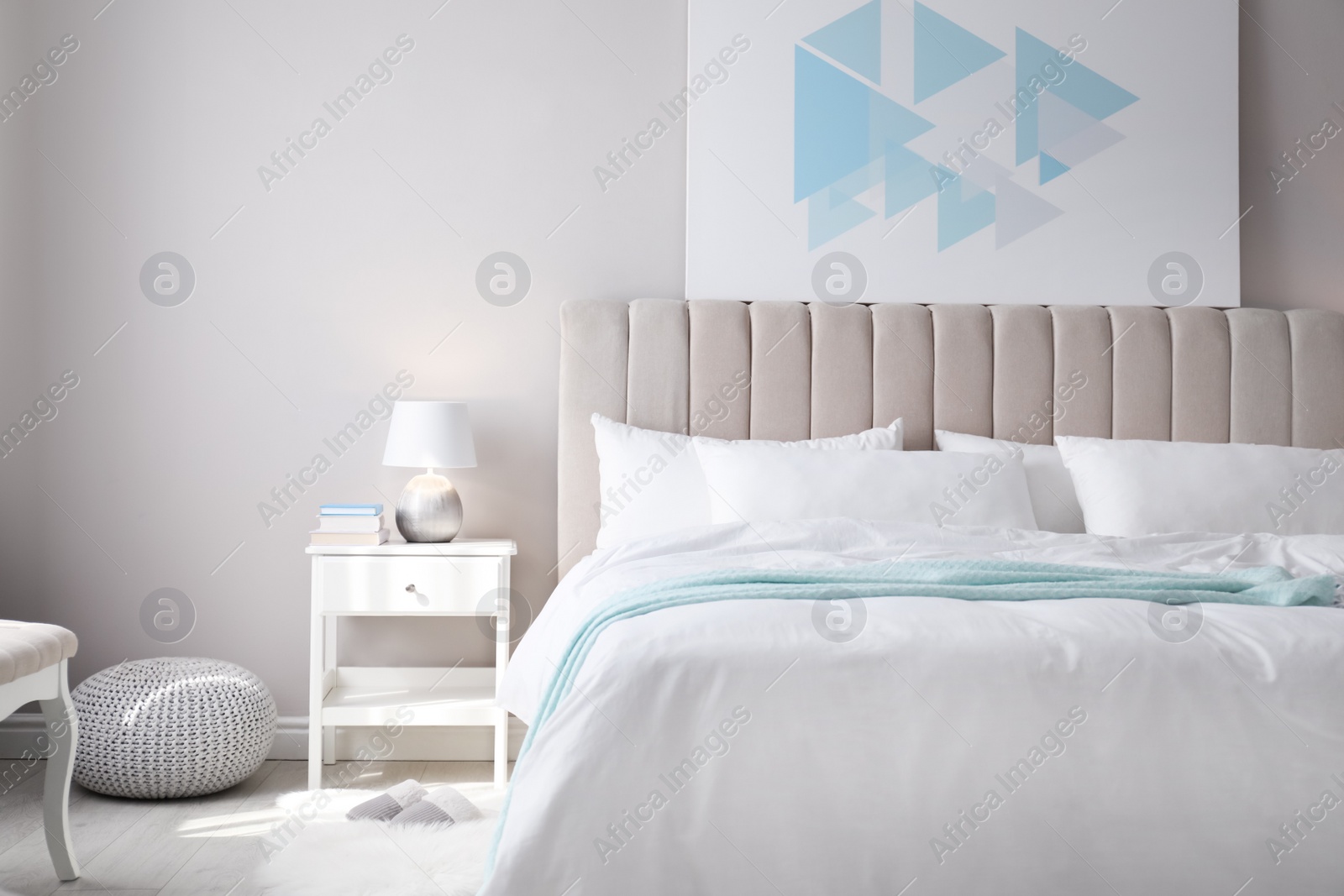 Photo of Cozy bed with soft linens in light room