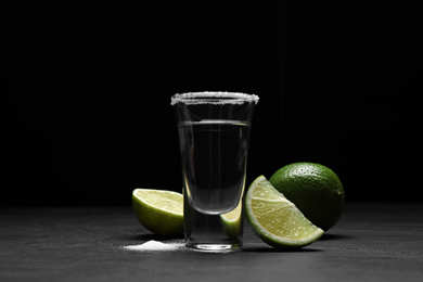 Photo of Mexican Tequila shot with salt and lime on black table