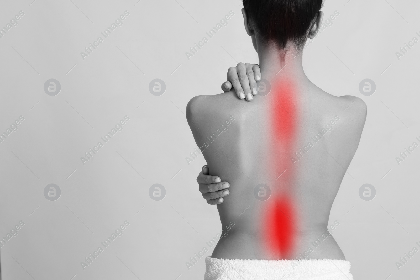 Image of Woman suffering from back pain on light background, space for text