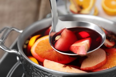 Photo of Delicious hot mulled wine in pot, closeup