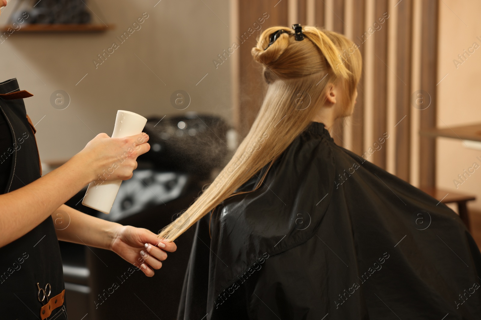 Photo of Professional hairdresser working with girl in beauty salon