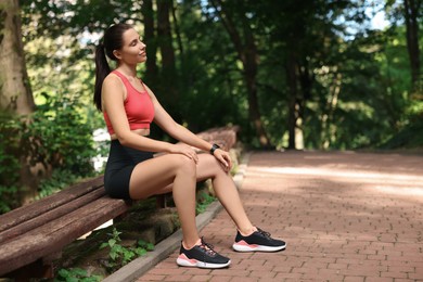 Photo of Beautiful woman in sportswear resting in park. Space for text