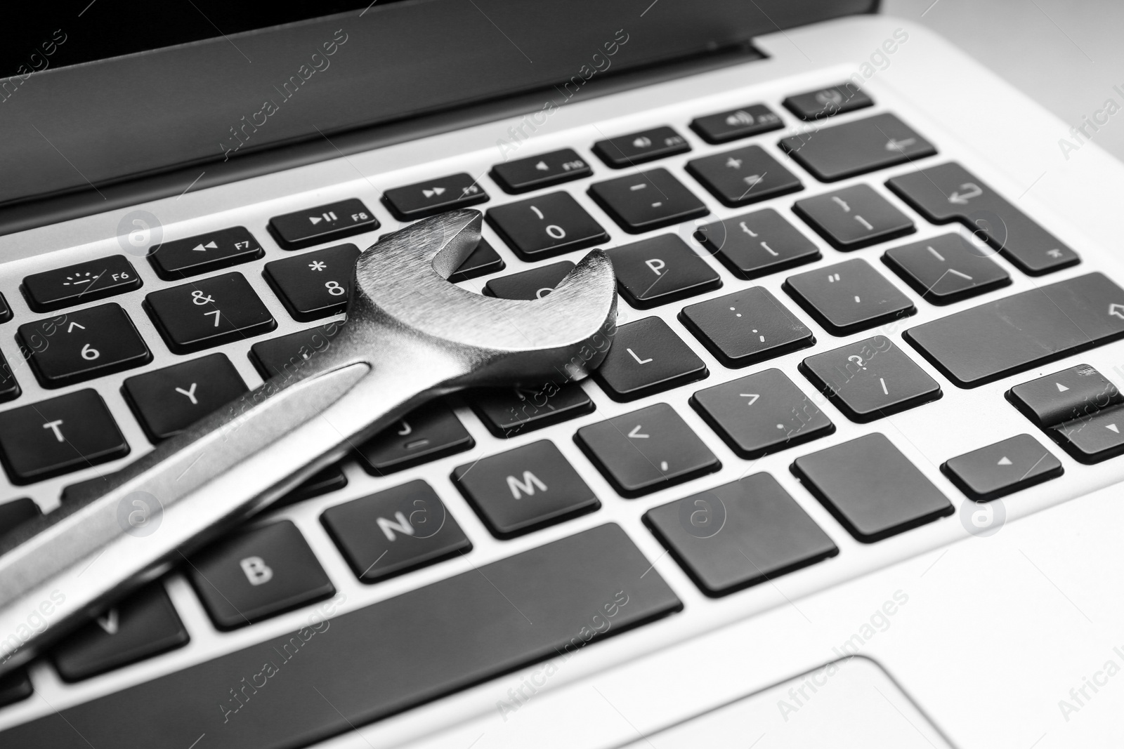 Photo of Spanner on laptop, closeup. Concept of technical support