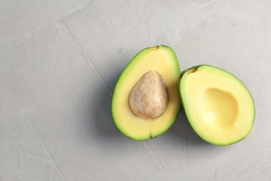 Photo of Tasty ripe green avocado on grey background, top view