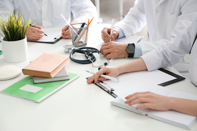 Photo of Doctors having meeting at table in office, closeup