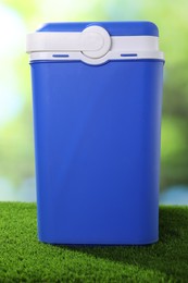 Photo of One plastic cool box on artificial grass, closeup
