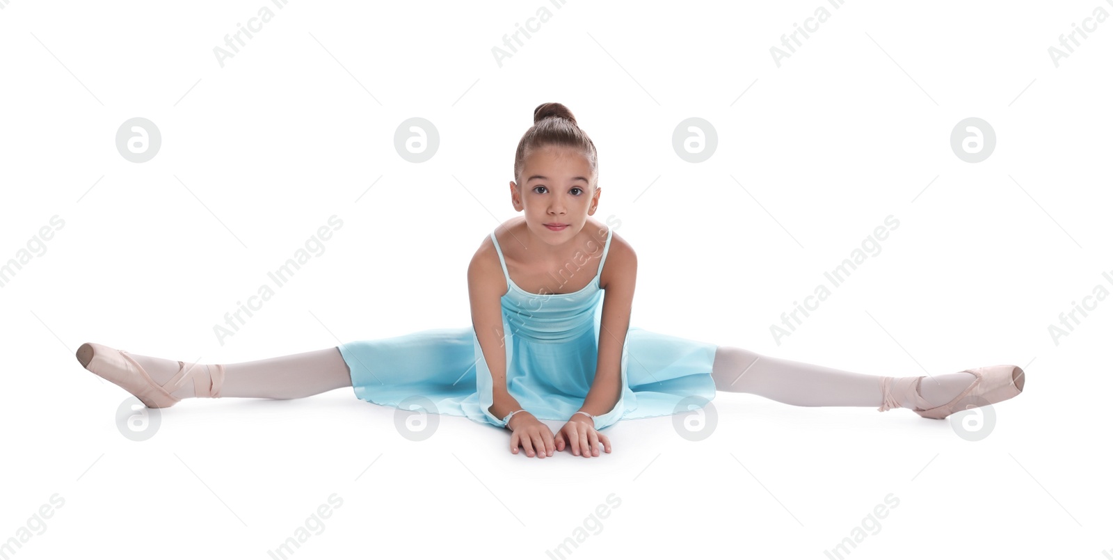 Photo of Beautifully dressed little ballerina sitting on split against white background