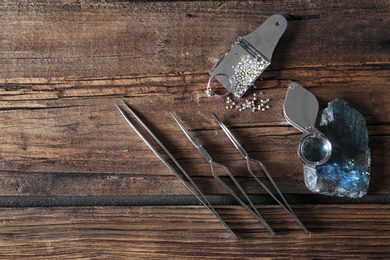 Flat lay composition with jewelry tools on wooden table