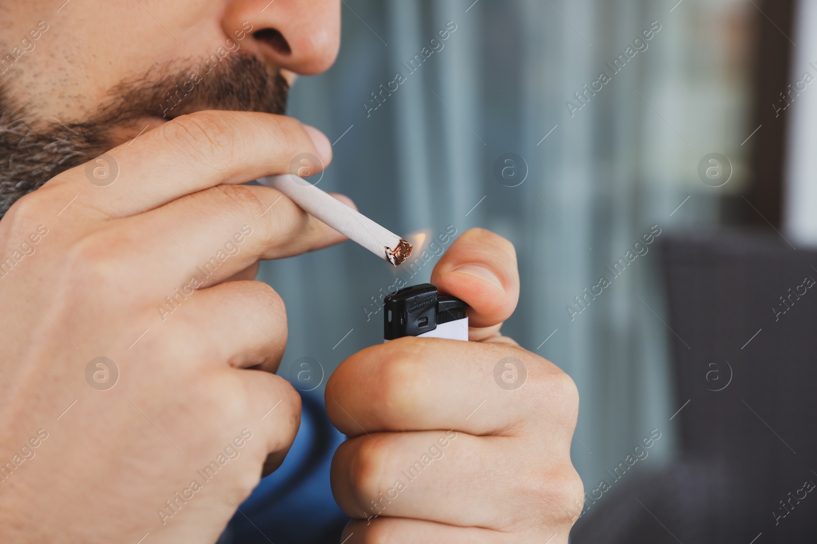 Photo of Mature man lighting cigarette, closeup of hands