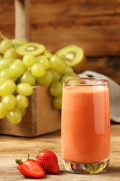 Photo of Glass with tasty smoothie on wooden table