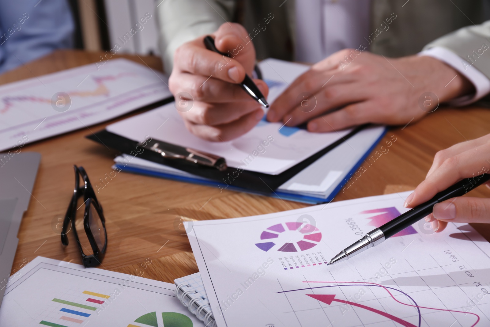 Photo of Business people working with charts and graphs at table, closeup. Investment analysis