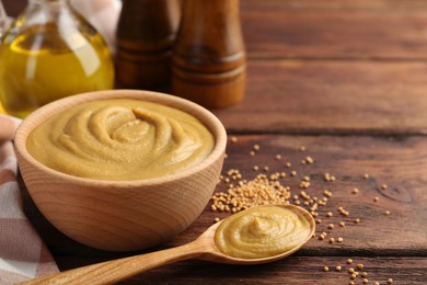 Photo of Tasty mustard sauce and dry seeds on wooden table, space for text
