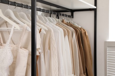 Photo of Rack with stylish women's clothes in dressing room