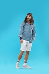 Photo of Stylish hippie man on light blue background