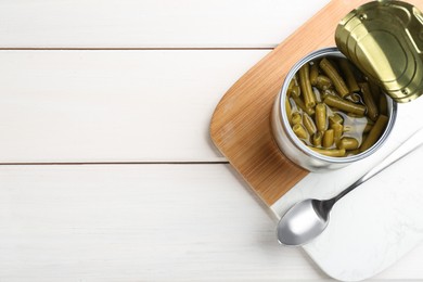 Photo of Canned green beans on white wooden table, top view. Space for text