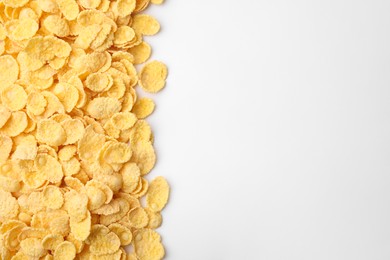 Photo of Breakfast cereal. Tasty corn flakes on white background, flat lay. Space for text